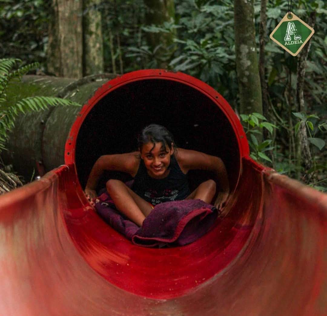 Criança se divertindo no Tobomata, atração de aventura da Aldeia em meio à mata
