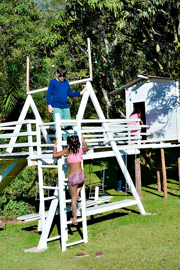 Crianças brincando no playground e na casinha da árvore da Aldeia